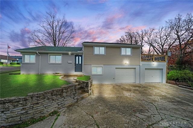 view of front of home with a garage and a yard