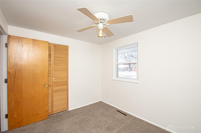 unfurnished bedroom with ceiling fan, a closet, and carpet floors