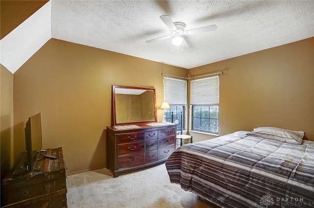 carpeted bedroom featuring a textured ceiling, ceiling fan, and lofted ceiling