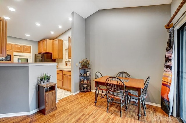 dining area with lofted ceiling and light hardwood / wood-style floors