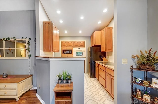 kitchen with light brown cabinets and black appliances