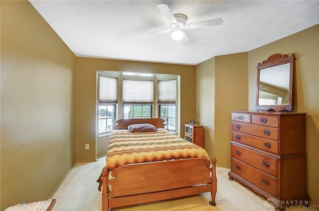 carpeted bedroom featuring ceiling fan and a textured ceiling