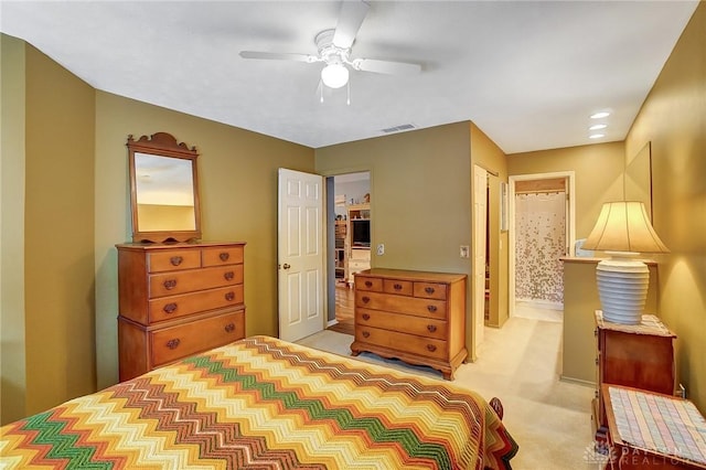 carpeted bedroom featuring ceiling fan and ensuite bathroom