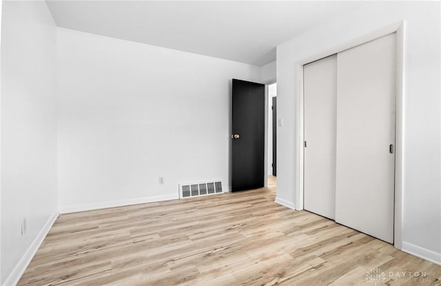 unfurnished bedroom featuring a closet and light hardwood / wood-style flooring