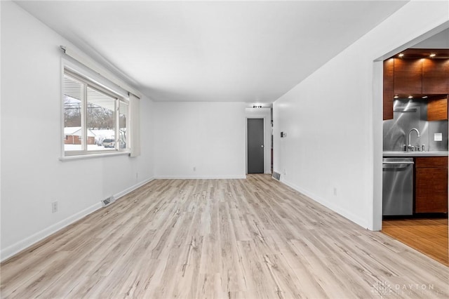 unfurnished living room with sink and light wood-type flooring