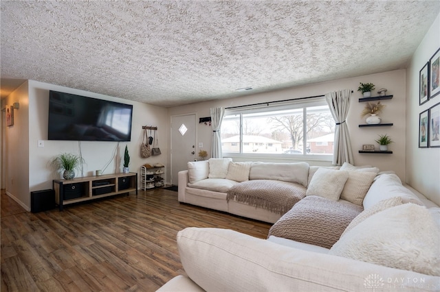 living room featuring dark wood-type flooring and a textured ceiling