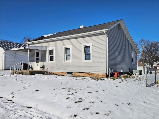 snow covered house with central air condition unit