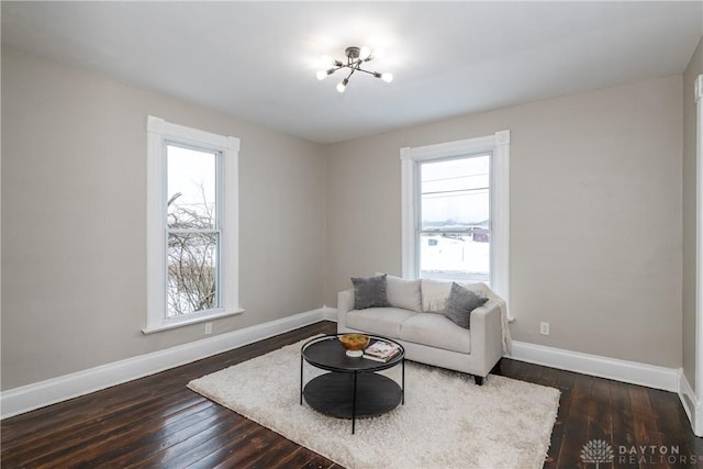 living room featuring dark wood-type flooring and a notable chandelier