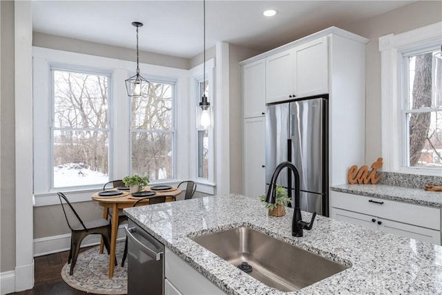 kitchen featuring light stone countertops, white cabinetry, dark hardwood / wood-style flooring, stainless steel appliances, and sink