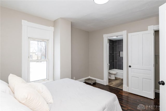 bedroom with dark wood-type flooring and connected bathroom