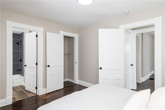 bedroom with a walk in closet, a closet, dark hardwood / wood-style flooring, and connected bathroom