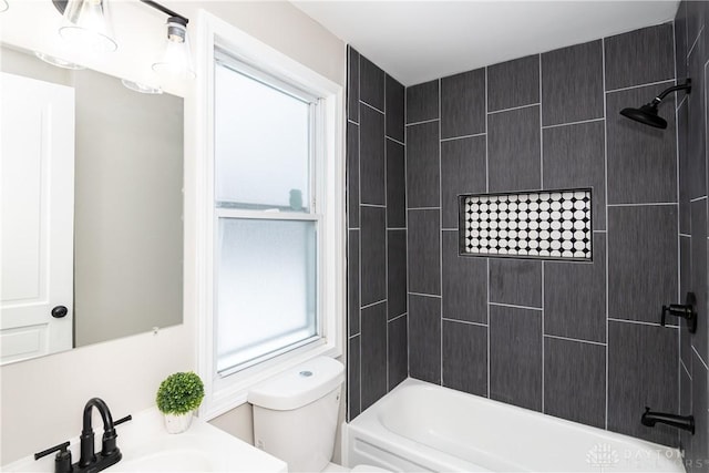 full bathroom with toilet, tiled shower / bath combo, and sink