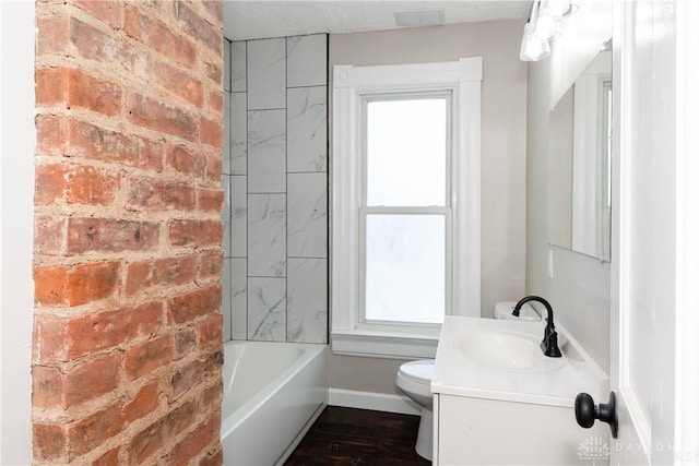 bathroom featuring toilet, vanity, brick wall, and hardwood / wood-style floors