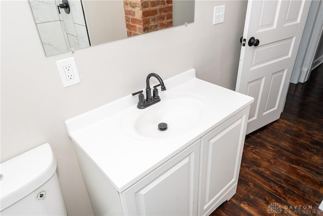 bathroom with toilet, vanity, and hardwood / wood-style flooring