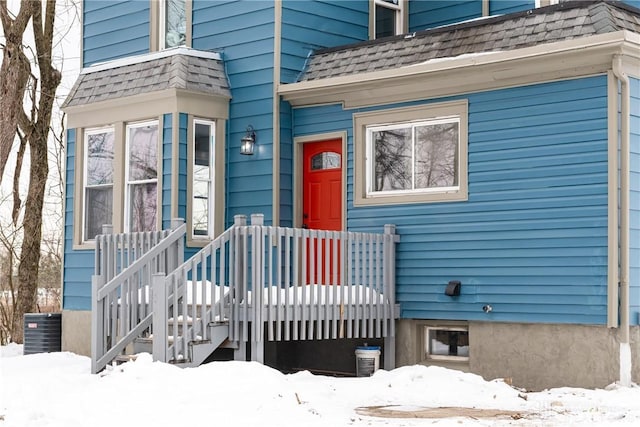 snow covered property entrance featuring central AC