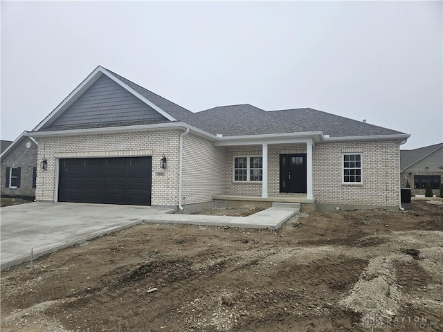 view of front of property featuring brick siding, concrete driveway, a garage, and a shingled roof