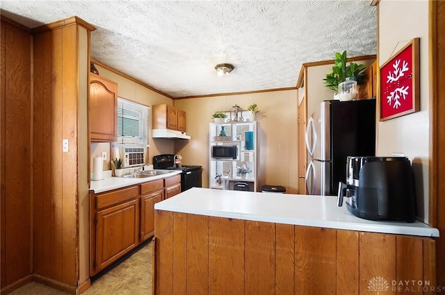 kitchen with kitchen peninsula, ornamental molding, stainless steel appliances, and a healthy amount of sunlight