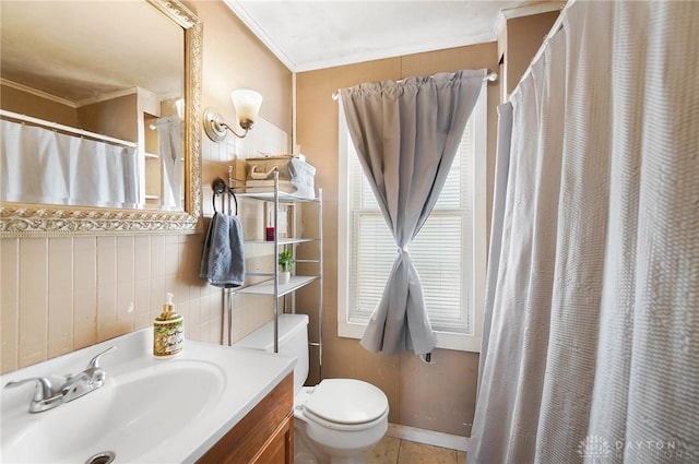 bathroom with toilet, vanity, crown molding, and tile patterned flooring