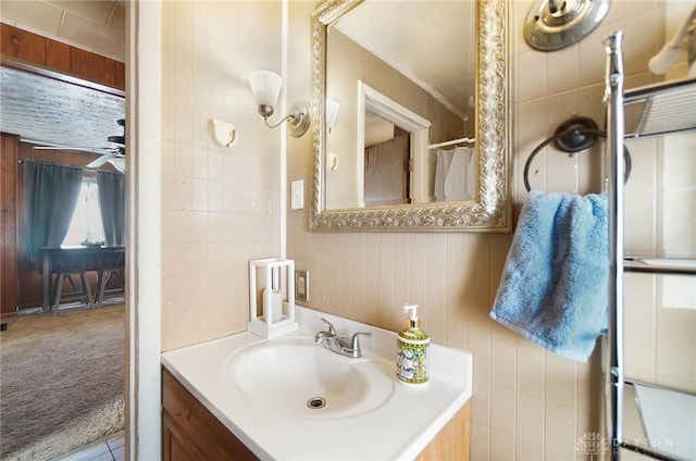 bathroom with ceiling fan, a shower with shower curtain, wood walls, and vanity