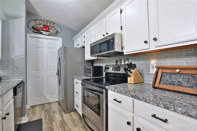 kitchen featuring light stone counters, light hardwood / wood-style flooring, white cabinets, and appliances with stainless steel finishes