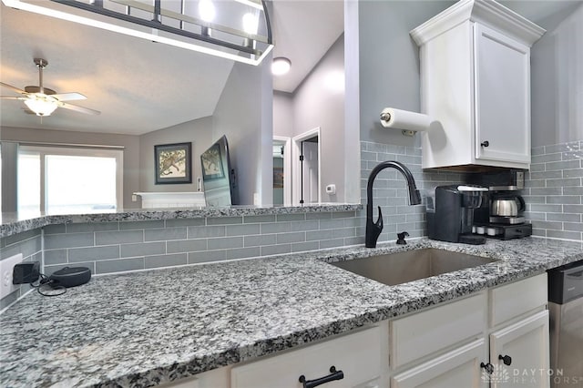 kitchen featuring sink, white cabinetry, tasteful backsplash, dishwasher, and light stone countertops