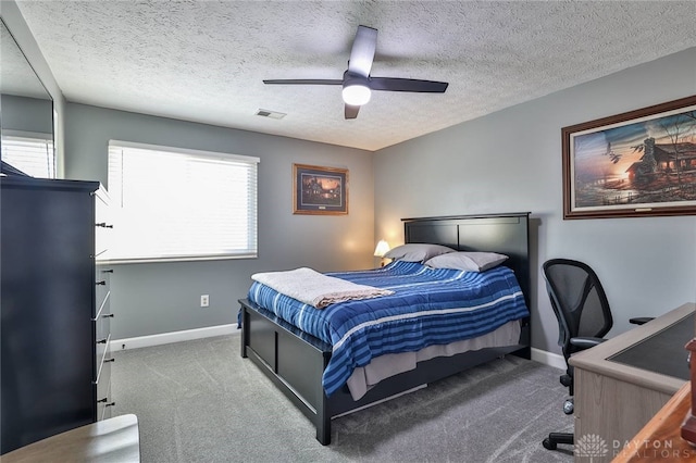 carpeted bedroom featuring ceiling fan and a textured ceiling