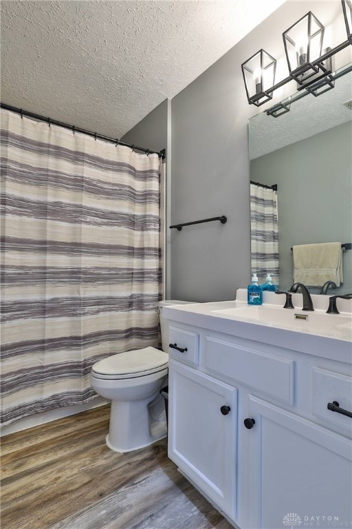 bathroom with vanity, hardwood / wood-style flooring, toilet, and a textured ceiling