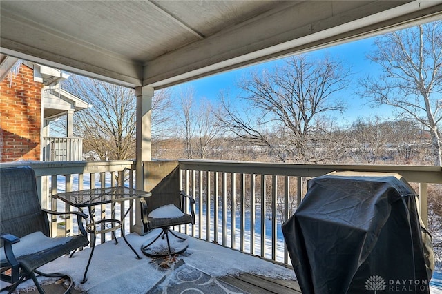 snow covered deck with a pool and a grill