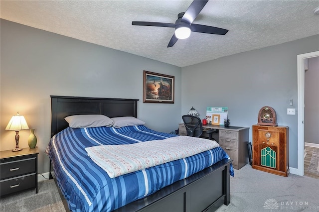 carpeted bedroom with ceiling fan and a textured ceiling