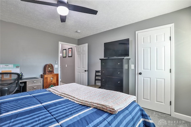 bedroom featuring ceiling fan, carpet, and a textured ceiling