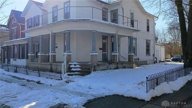 view of snowy exterior featuring covered porch