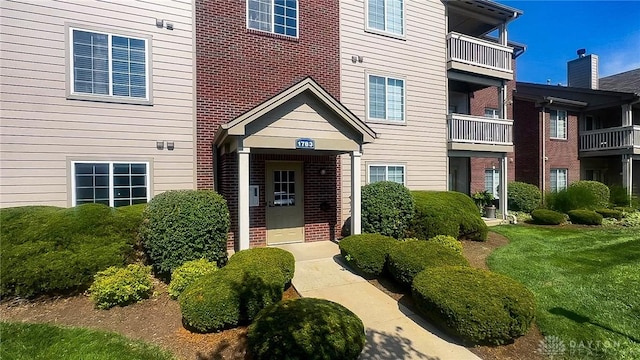 view of exterior entry with a lawn