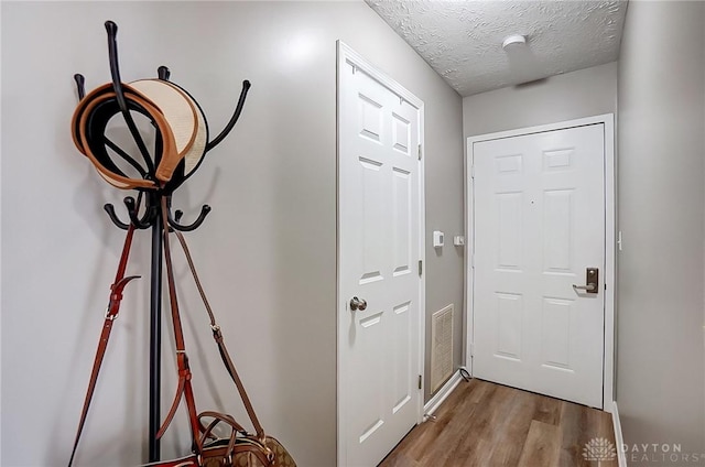 entryway with a textured ceiling and light wood-type flooring