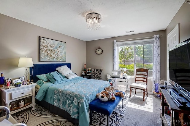 carpeted bedroom featuring a notable chandelier