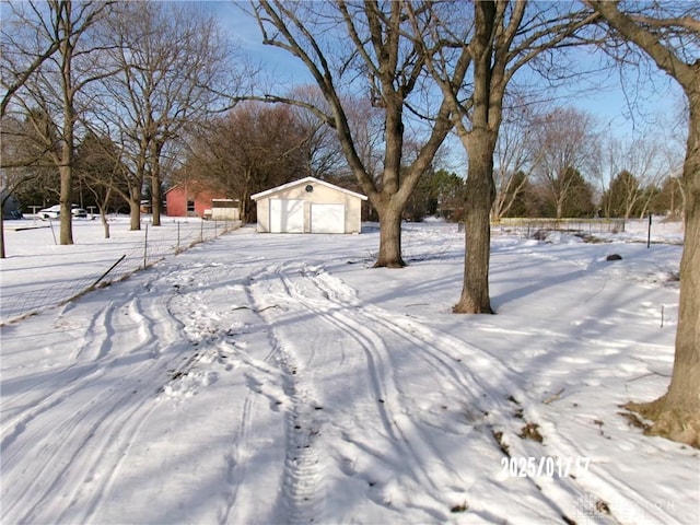 yard layered in snow with a garage and an outdoor structure