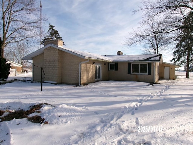 view of snow covered rear of property