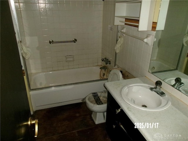 full bathroom featuring toilet, tiled shower / bath combo, and vanity