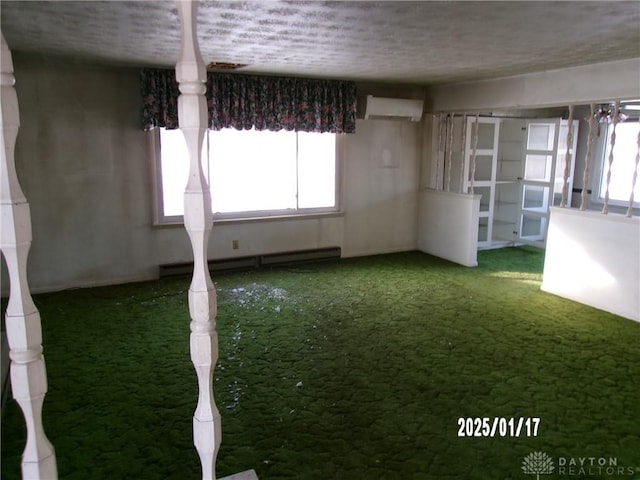 unfurnished room with a baseboard heating unit, carpet, and an AC wall unit