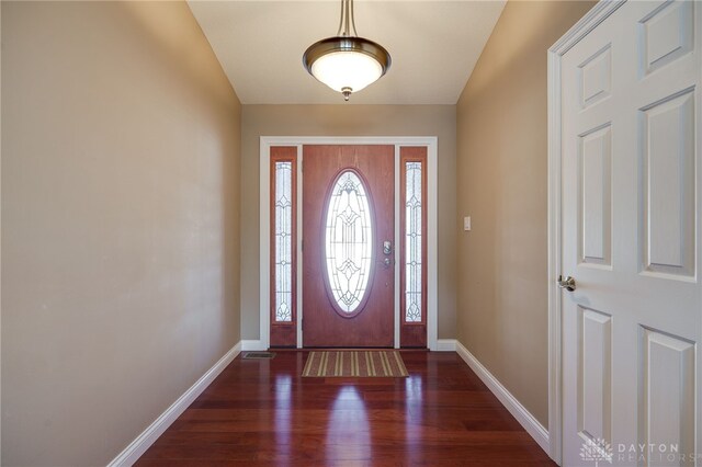 foyer with dark hardwood / wood-style floors and vaulted ceiling