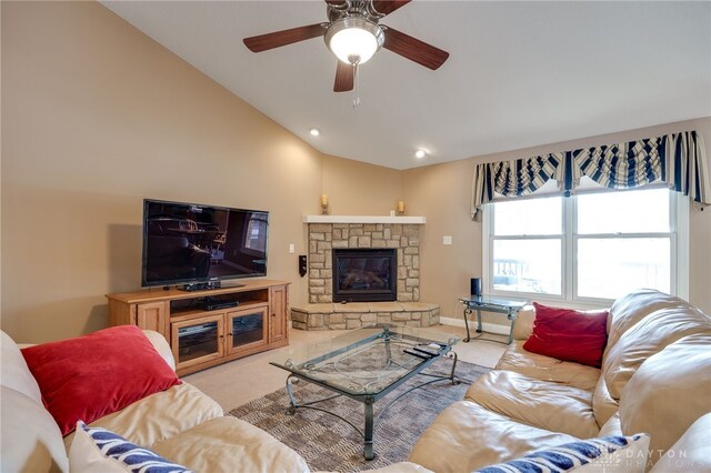 living room featuring ceiling fan, light colored carpet, a stone fireplace, and vaulted ceiling