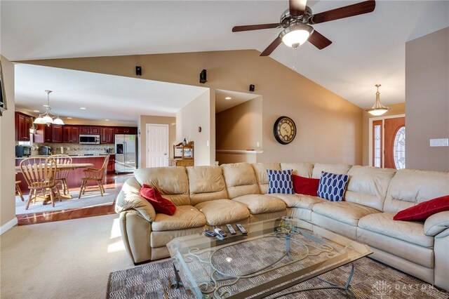 carpeted living room featuring ceiling fan and vaulted ceiling