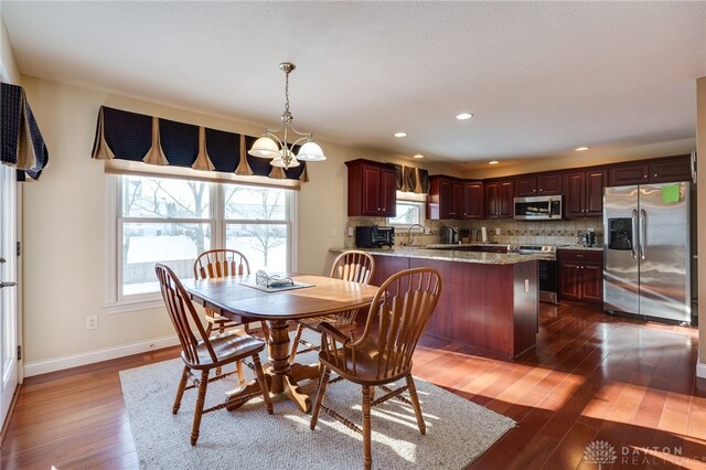 dining area featuring an inviting chandelier, dark hardwood / wood-style floors, and sink