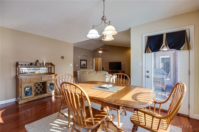 dining area with ceiling fan, a wealth of natural light, dark hardwood / wood-style floors, and vaulted ceiling