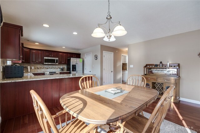 dining space featuring dark hardwood / wood-style flooring and a notable chandelier