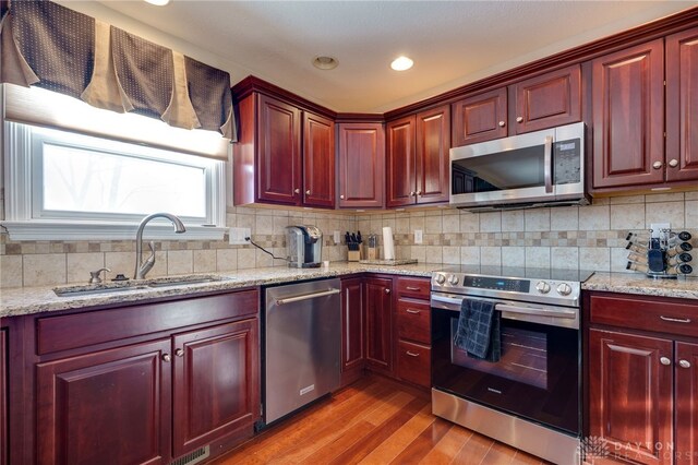 kitchen with light stone countertops, sink, and appliances with stainless steel finishes