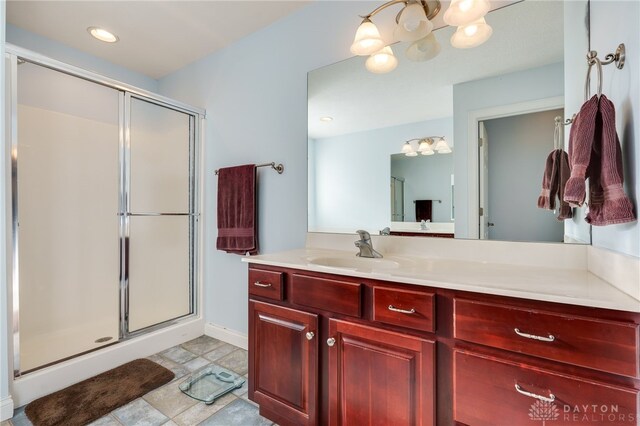 bathroom with a shower with door and vanity