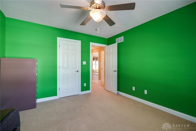 unfurnished bedroom with ceiling fan and light colored carpet