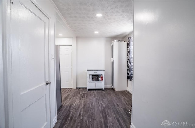 corridor featuring a textured ceiling and dark hardwood / wood-style flooring