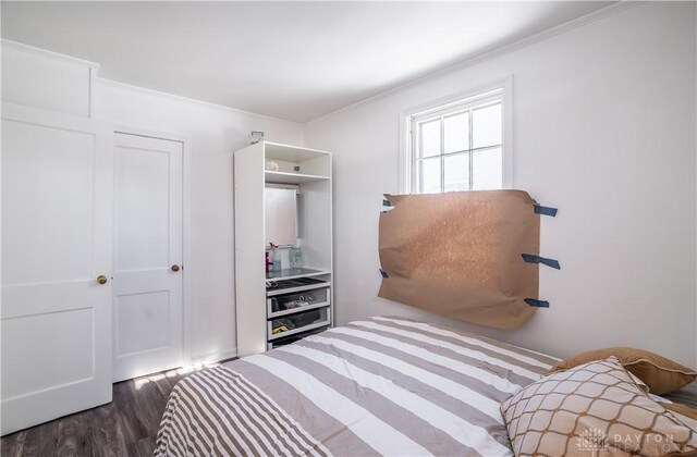 bedroom with dark wood-type flooring and a closet