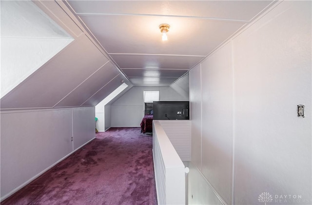 bonus room with lofted ceiling and dark carpet